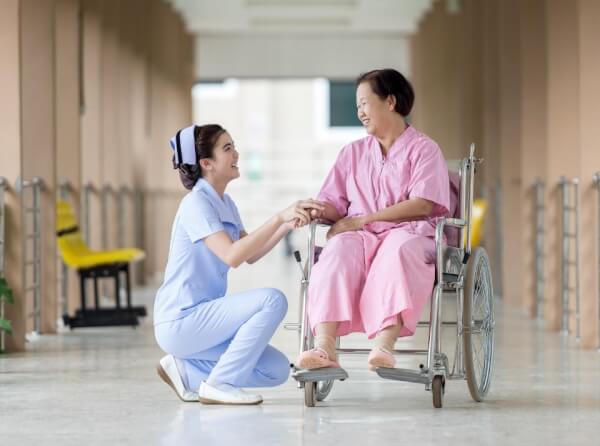 a nurse is talking to a patient happily in a hospital hall