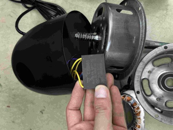 AC fan motor capacitor fitted beside the motor housing